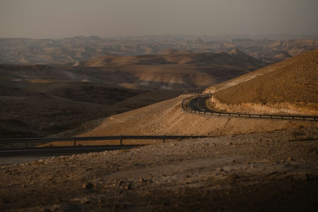 Estrada no deserto de Israel ao entardecer evocando o caminho de Emaús