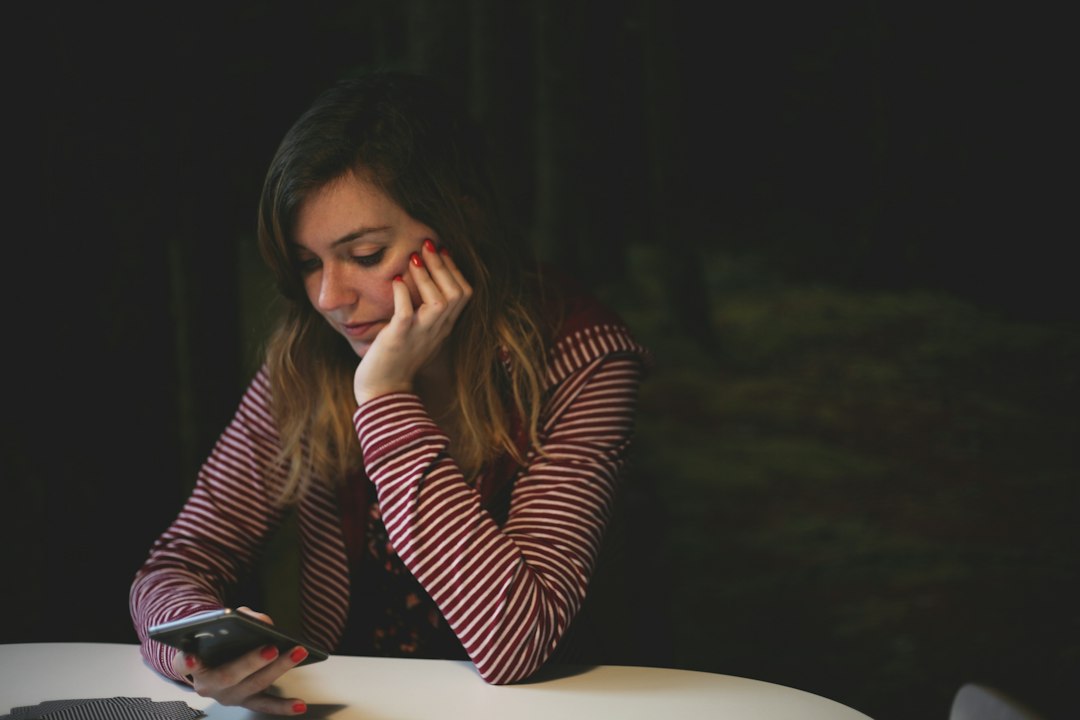 Mulher olhando para o celular durante um momento de ansiedade no relacionamento