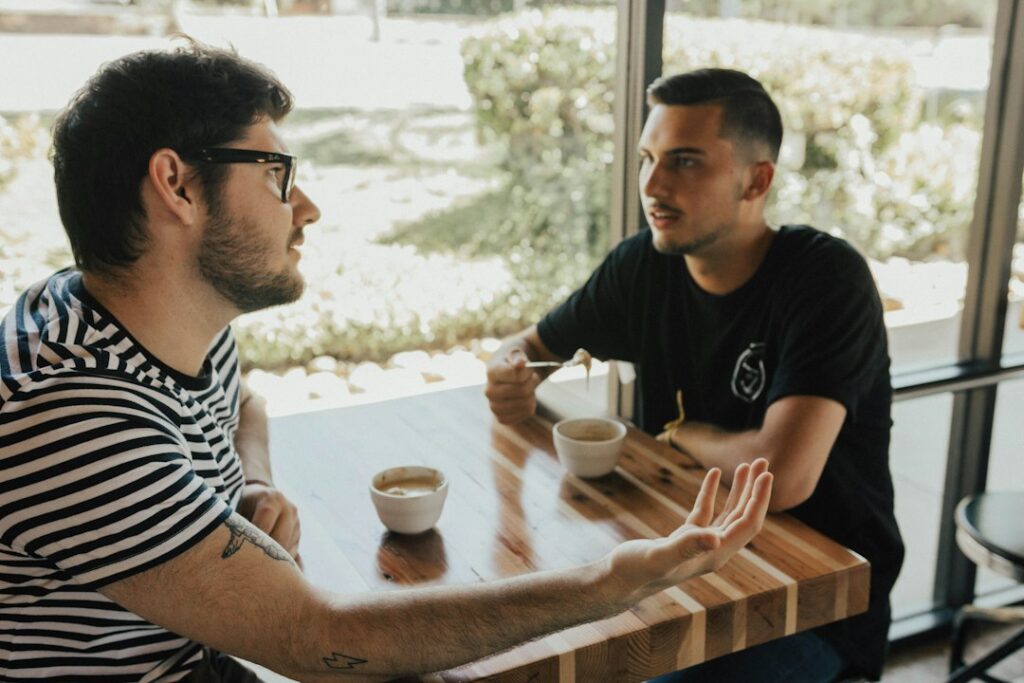 Dois homens conversam em encontro de acompanhamento e cuidado