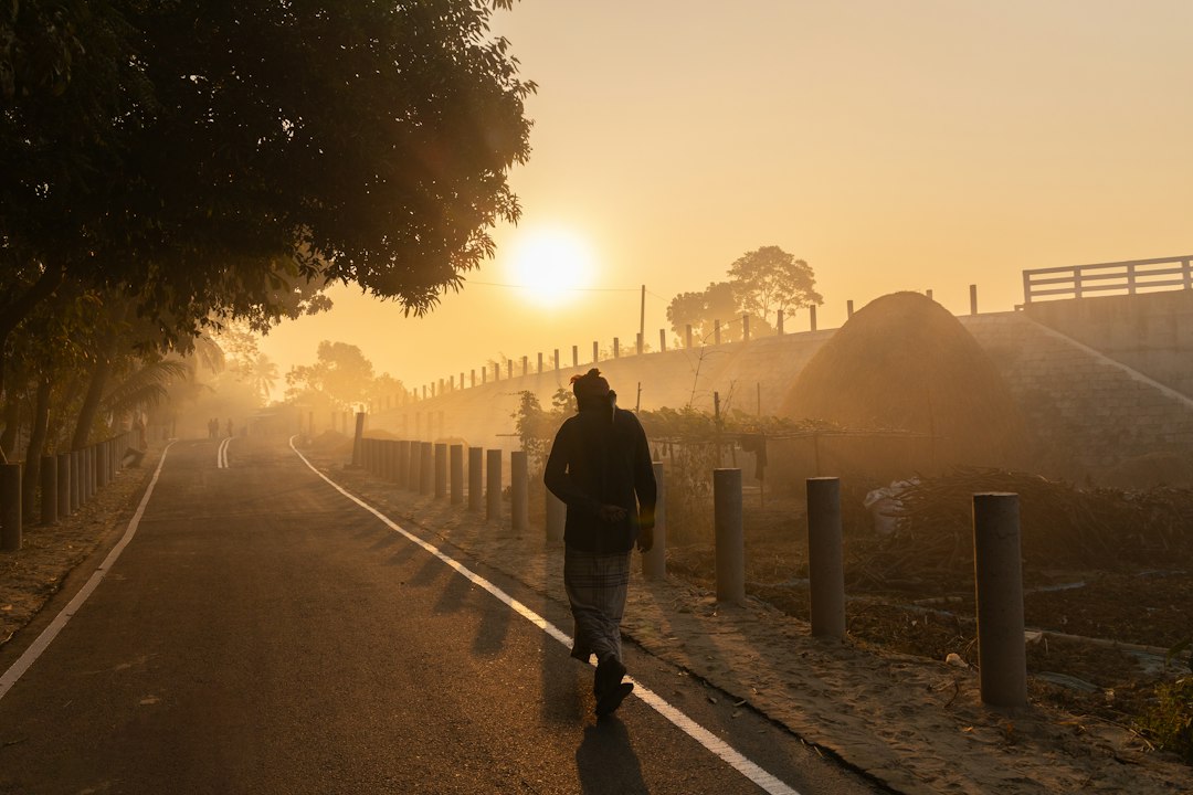 Pessoa caminhando em uma estrada ao amanhecer